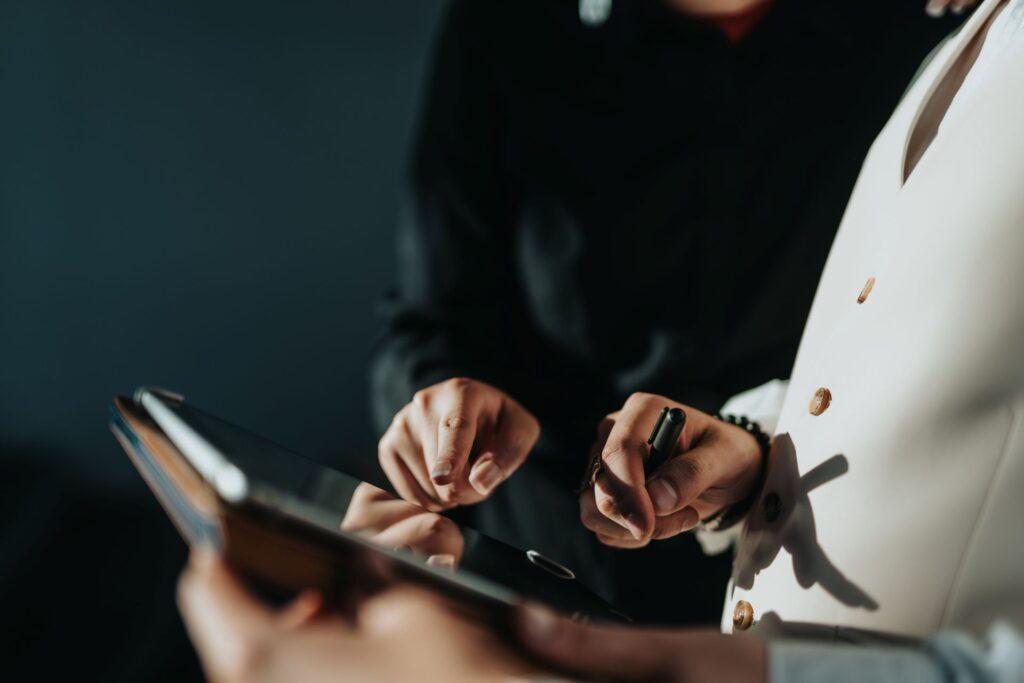 Close-up of two professionals using a tablet for planning – symbolizing collaboration and task management supported by an onlyfans agency