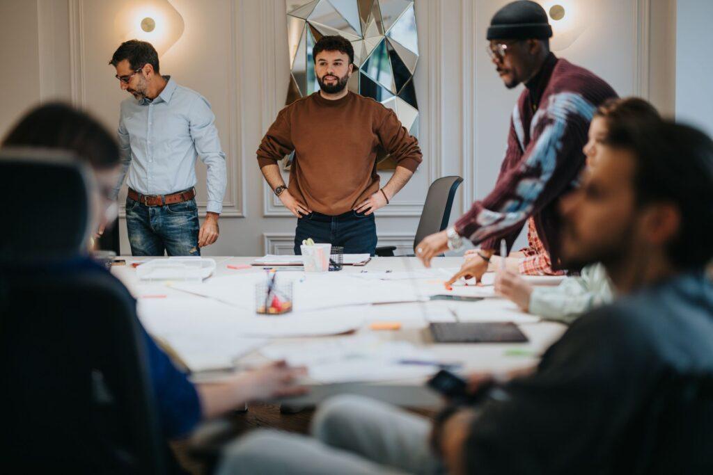 Creative team discussing strategy around a table – illustrating teamwork and structured support provided by an onlyfans agency